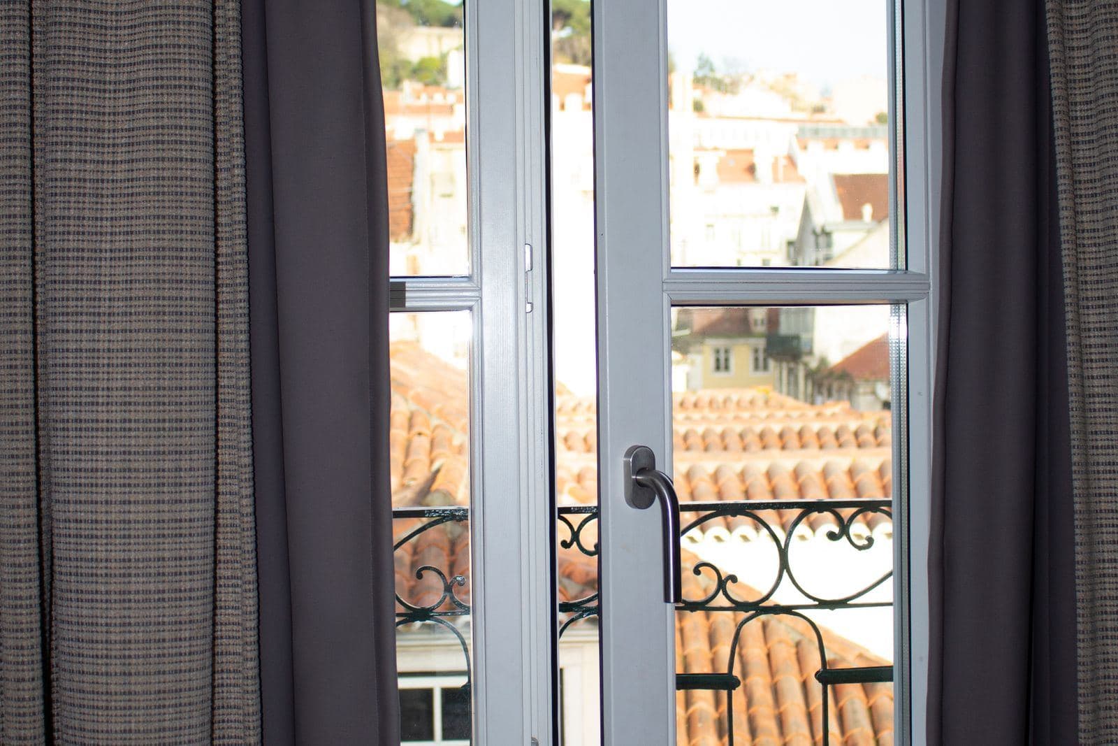 Geöffnetes Fenster mit Blick über Dächer und Balkone