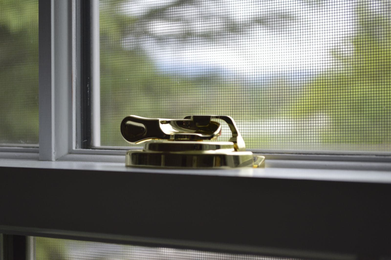Fenstergriff und Beschlagteil auf einer Fensterbank in Nahaufnahme