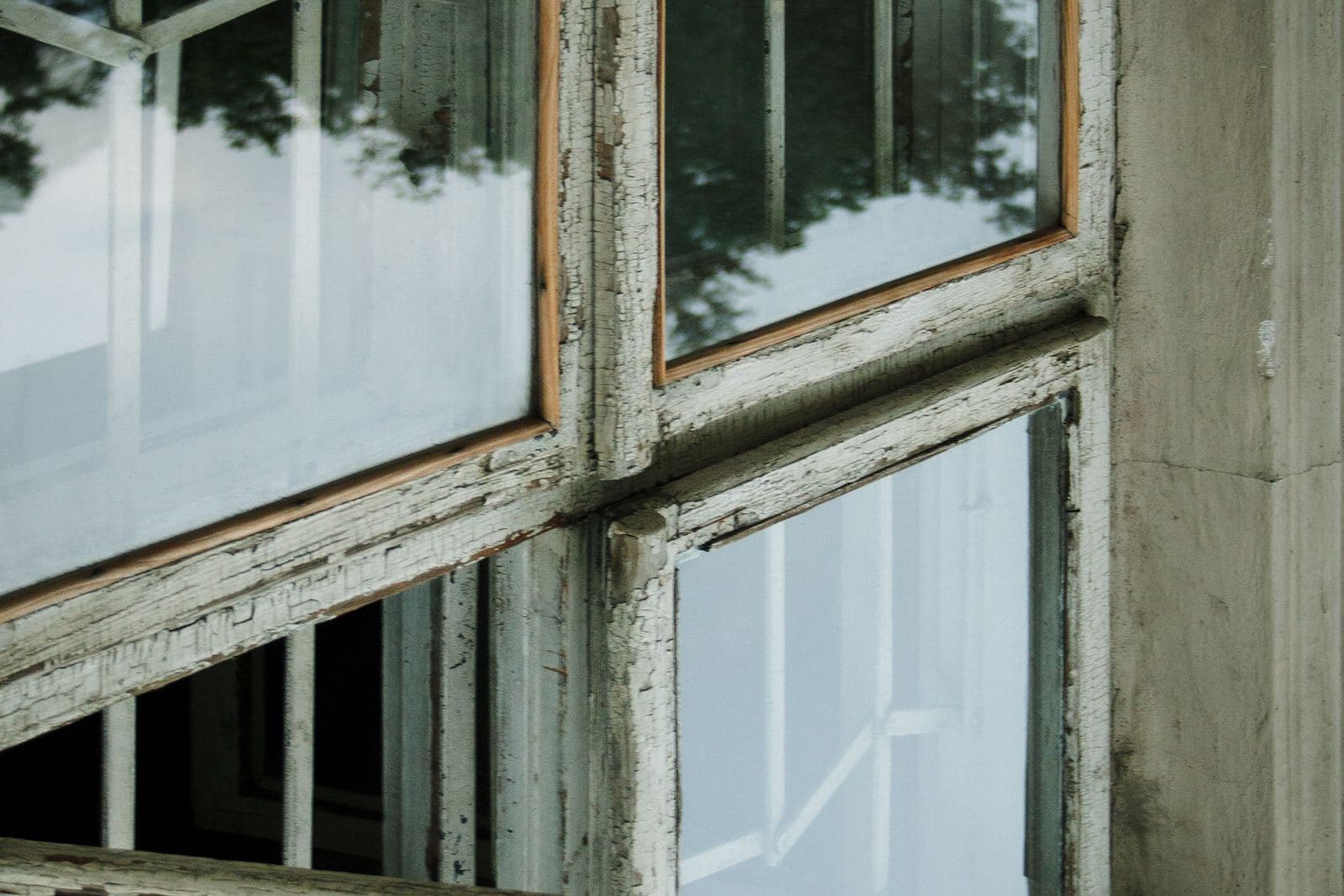 Altes Fenster mit verwittertem Rahmen und abblätternder Farbe