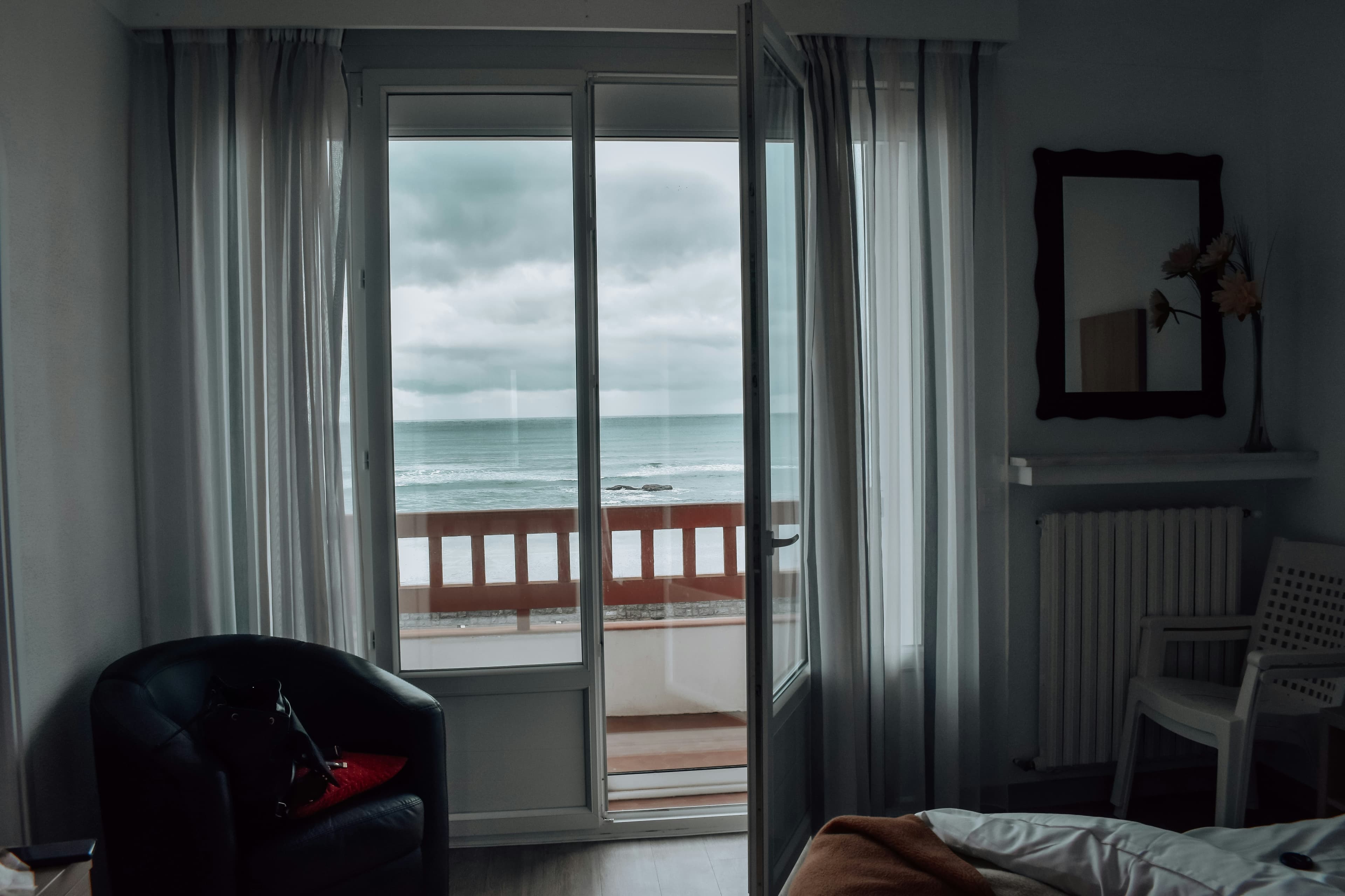 Geöffnete Balkontür mit Blick auf das Meer